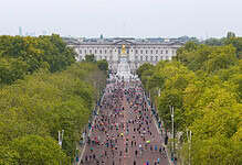 Crowd of runners participating in the Royal Parks Half Marathon with Buckingham Palace in the background.