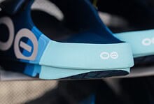 Close-up of blue and black running shoes and gear on display at Running Insights store, highlighting athletic footwear and accessories for runners.